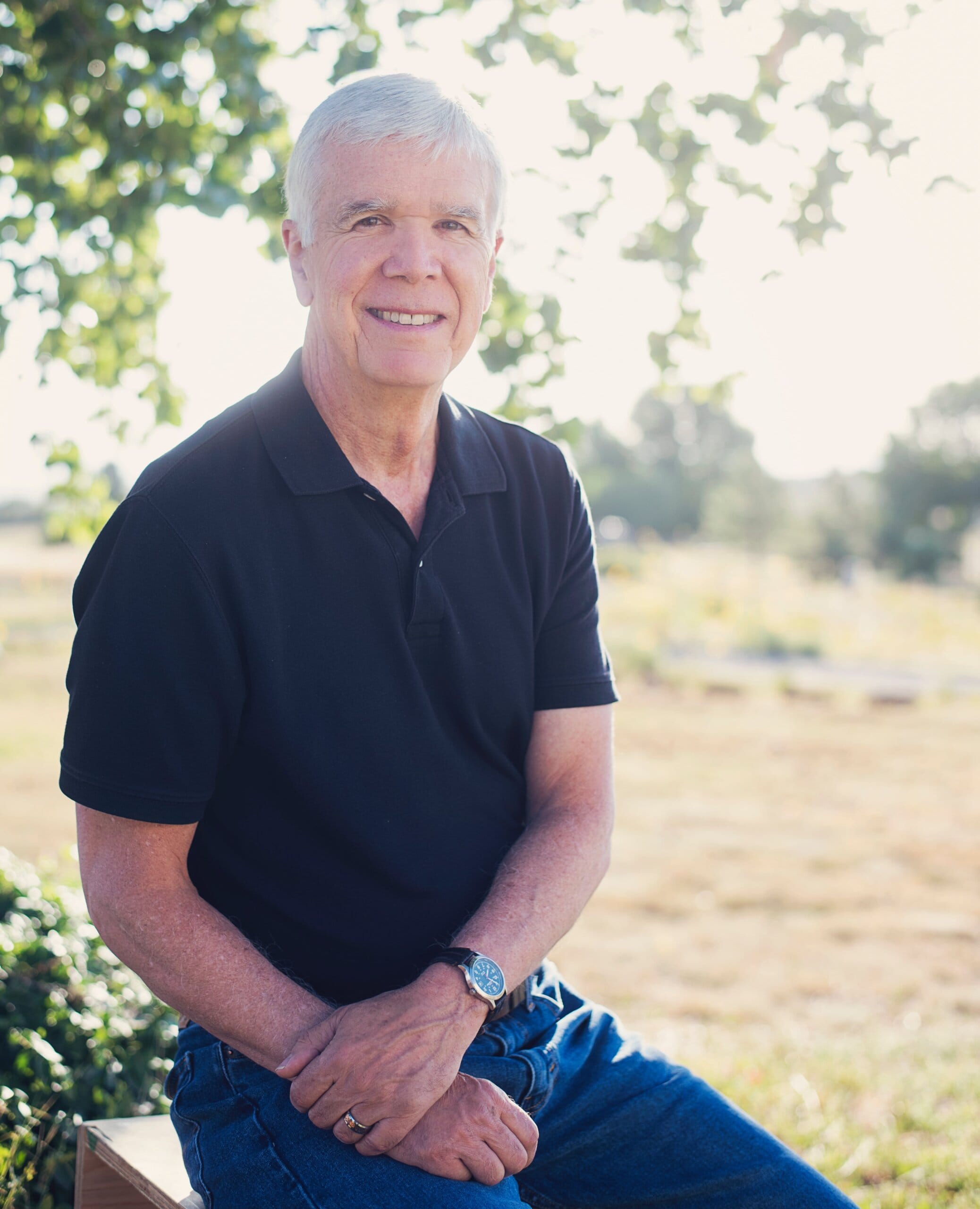 A portrait of Dr. Vernon Redd in a sunny outdoor setting smiling at the camera