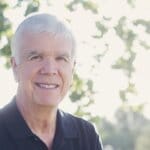A portrait of Dr. Vernon Redd in a sunny outdoor setting smiling at the camera
